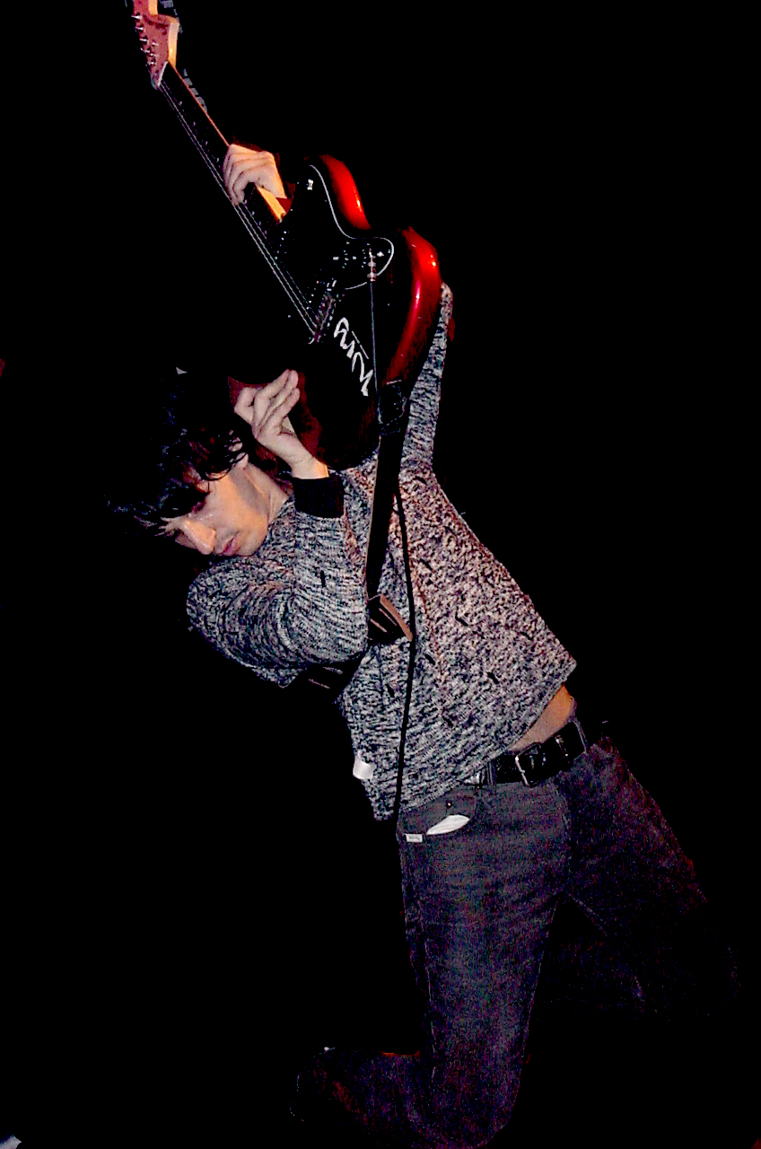 Musician lifting a guitar during a live performance